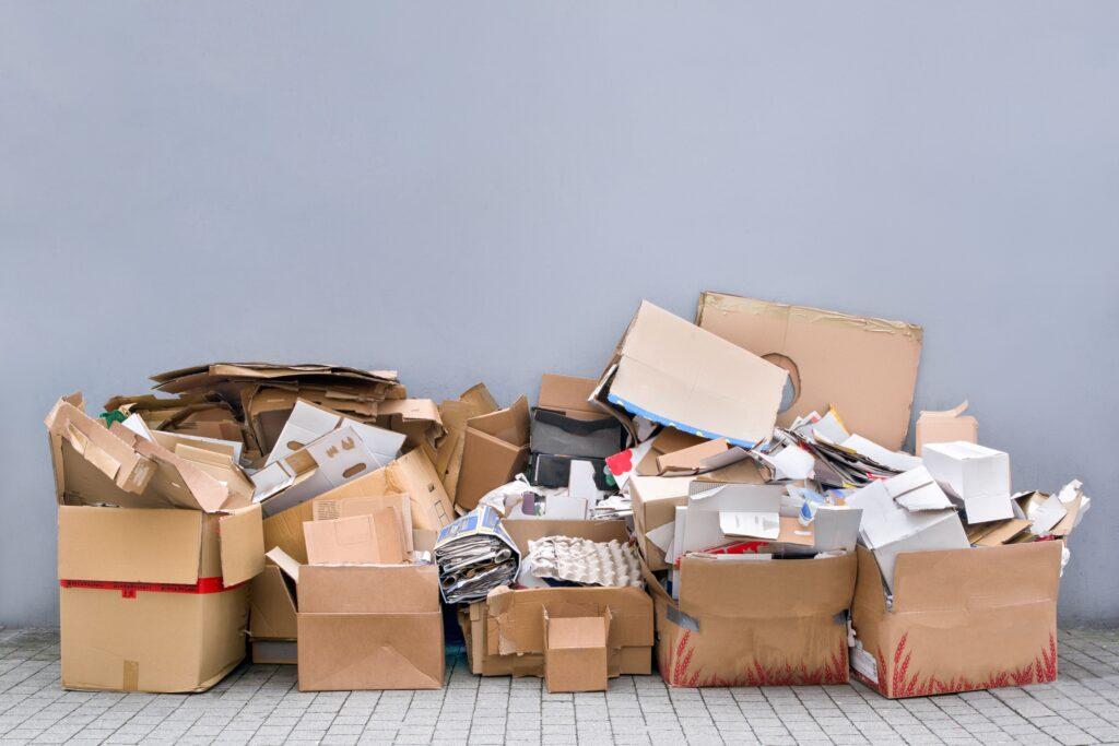 Ein Haufen von leeren, zerrissenen Kartons und Verpackungsmaterialien auf dem Gehweg, Teil einer Entrümpelung in Essen.